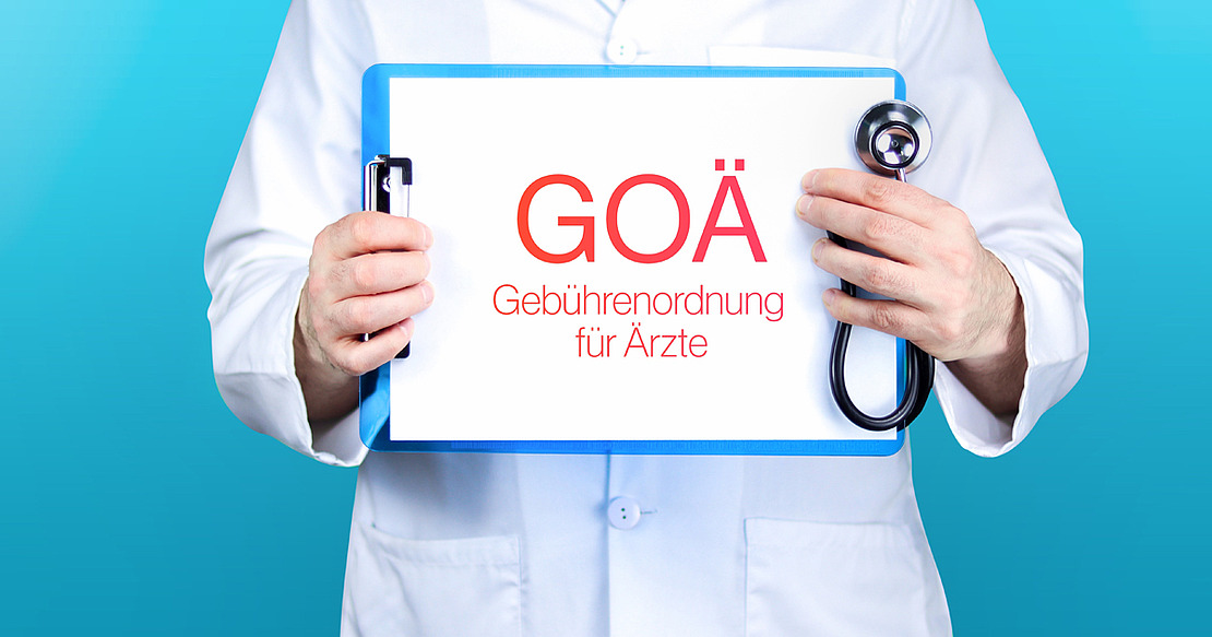 Arzt hält blaues Schild mit der Aufschrift "GOÄ (Gebührenordnung für Ärzte)"
