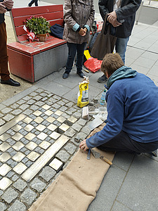 Mann verlegt Stolpersteine