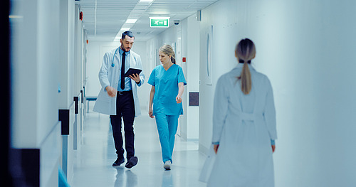 © Gorodenkoff / stock.adobe.com Junge Chirurgin und Arzt mit Tablet im Krankenhausflur